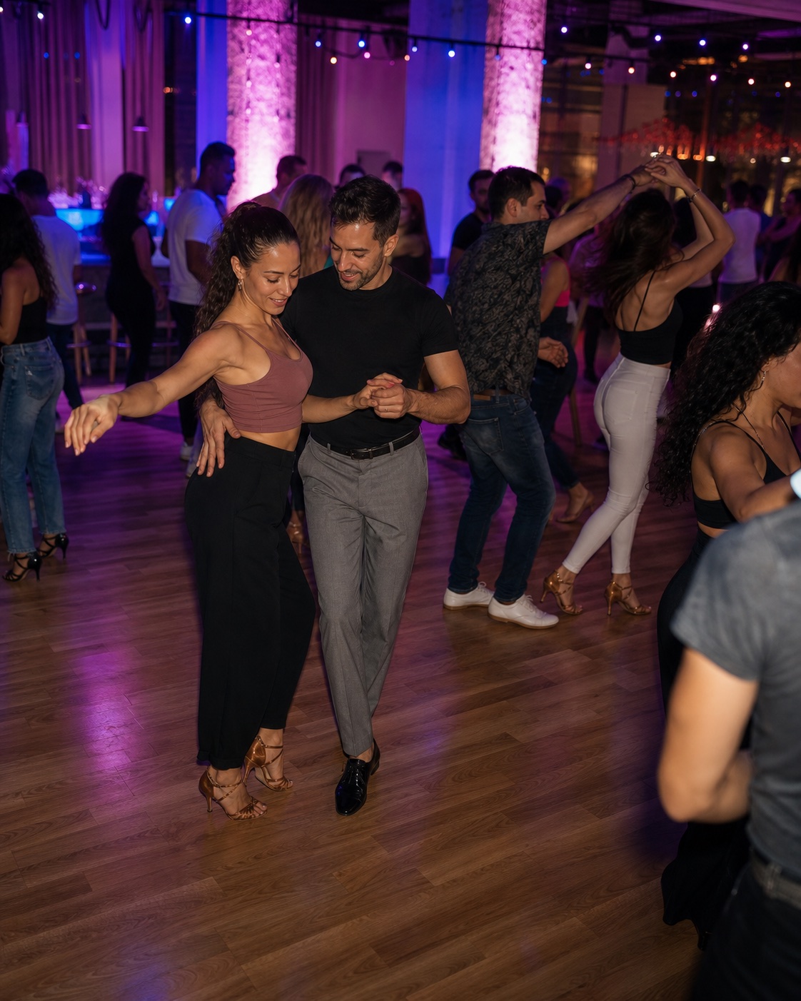 Parejas bailando en un social nocturno con luces de sala